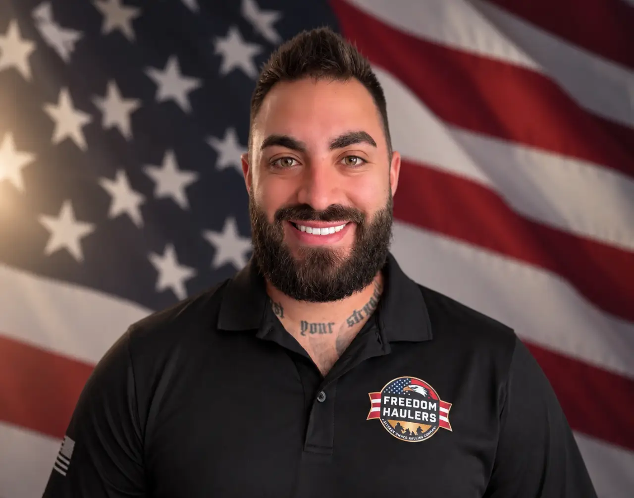 Ben D’Angelo, Army veteran owner of Freedom Haulers, wearing a company polo shirt in front of an American flag