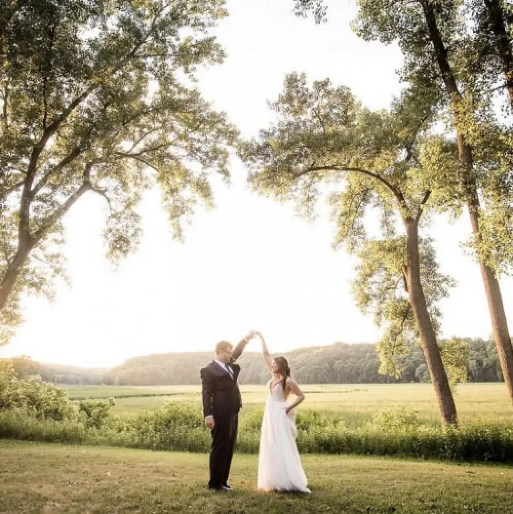 bride and groom holding hands under trees