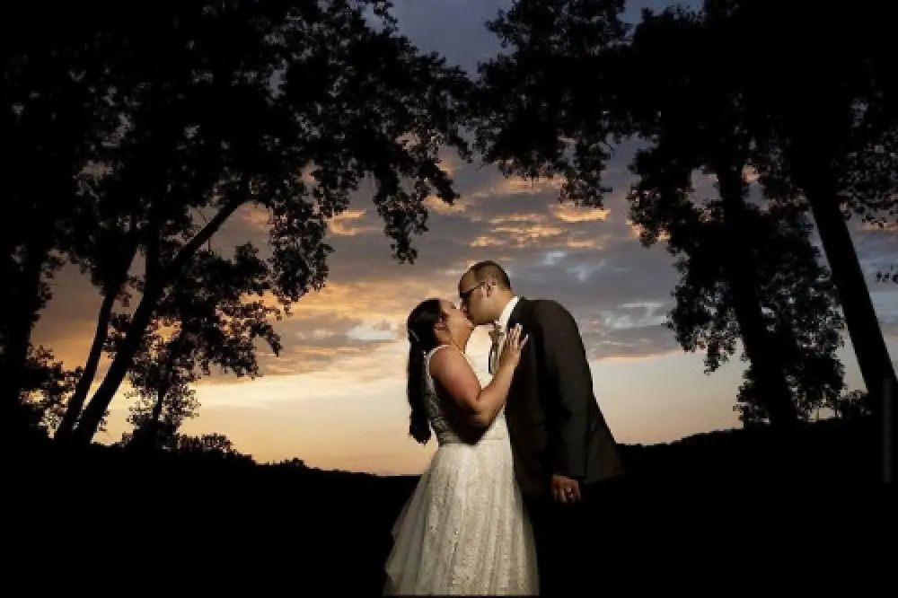 bride groom kissing at sunset