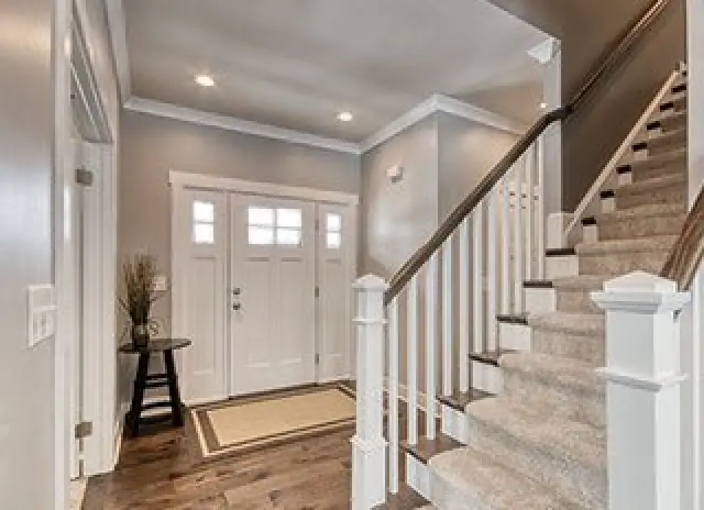 tan entryway with white wood accents and brown flooring