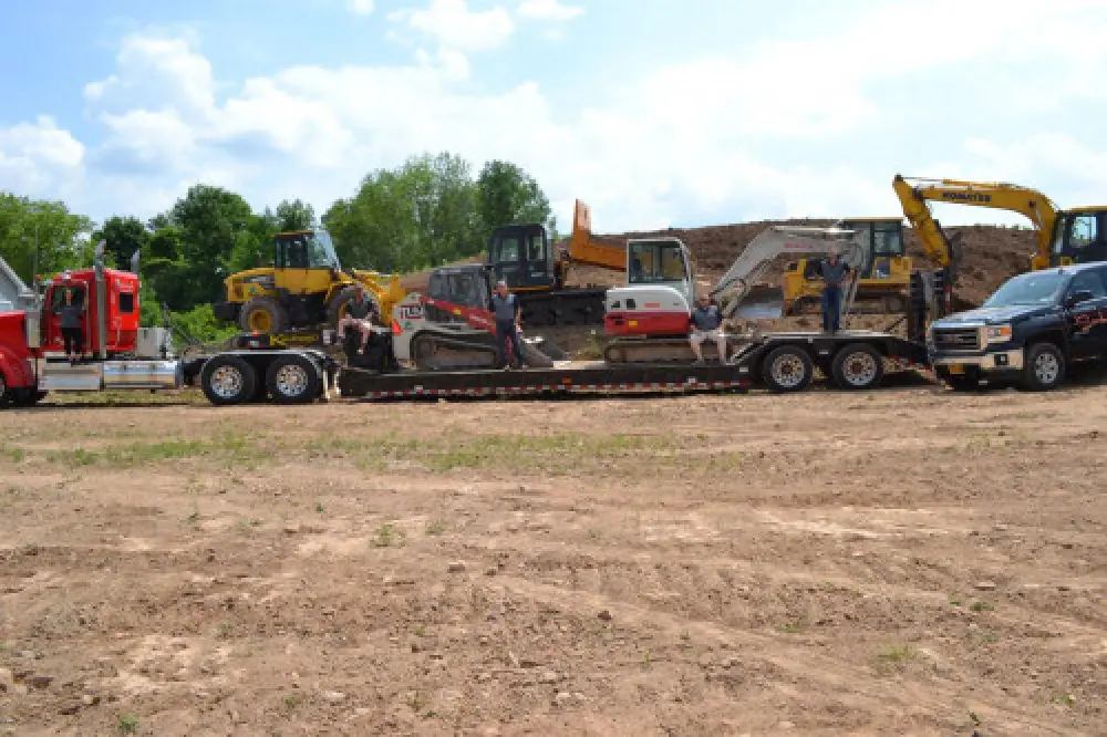 Sortino Properties demolition team on a flatbed with exavation equipment.