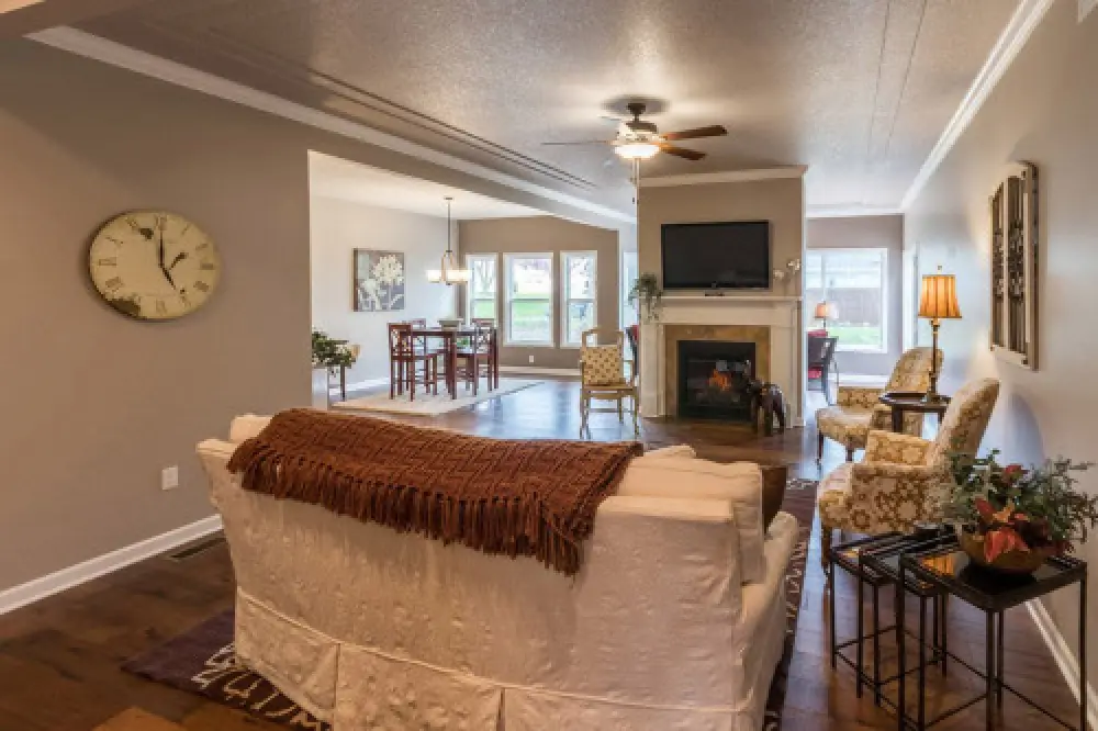Living room with fireplace and mounted flatscreen tv in a Villas at Churchville ranch home by Sortino Properties.