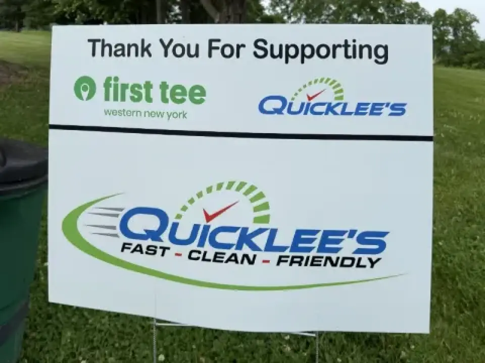 Sponsor sign on grass thanking First Tee WNY and Quicklees, reading Fast - Clean - Friendly.