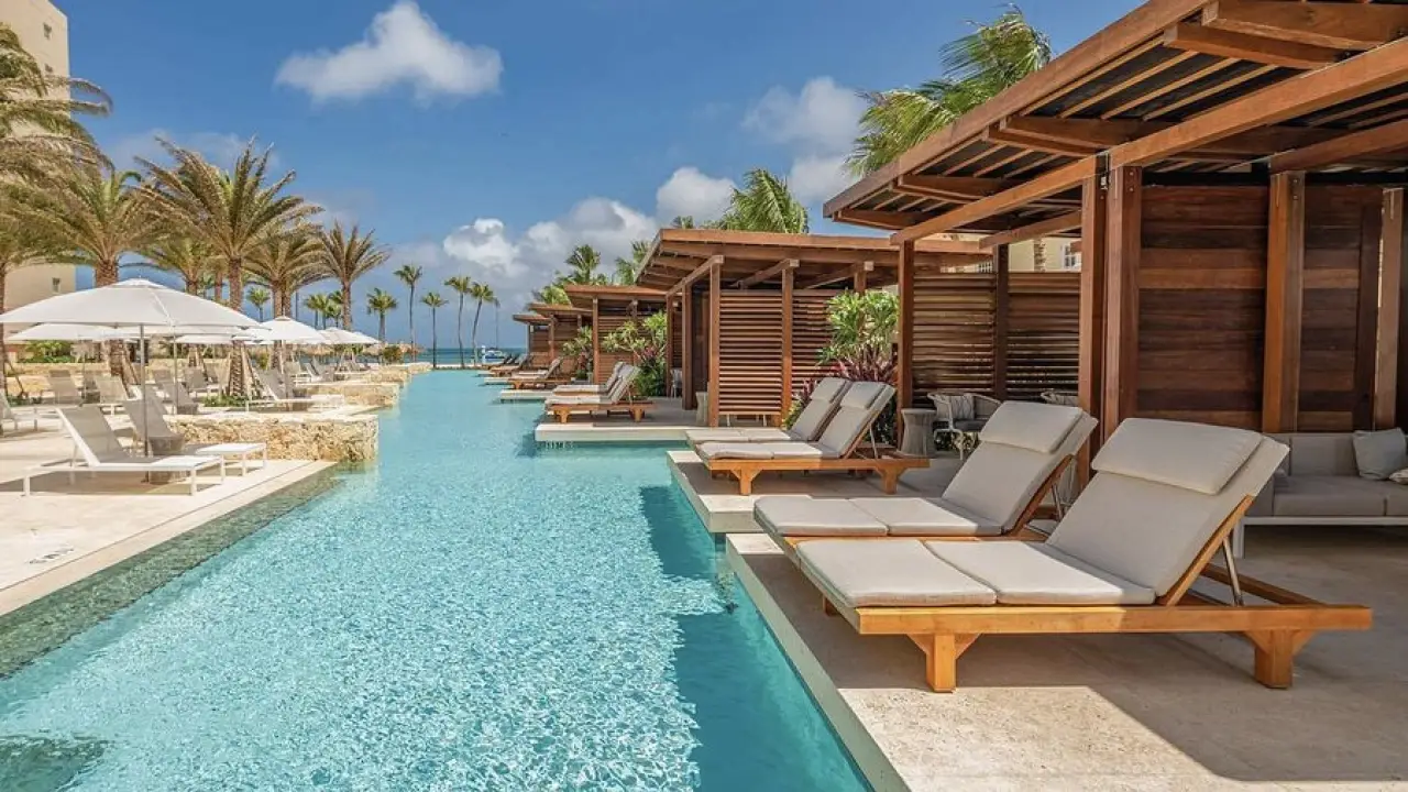 a pool with lounge chairs and umbrellas next to it