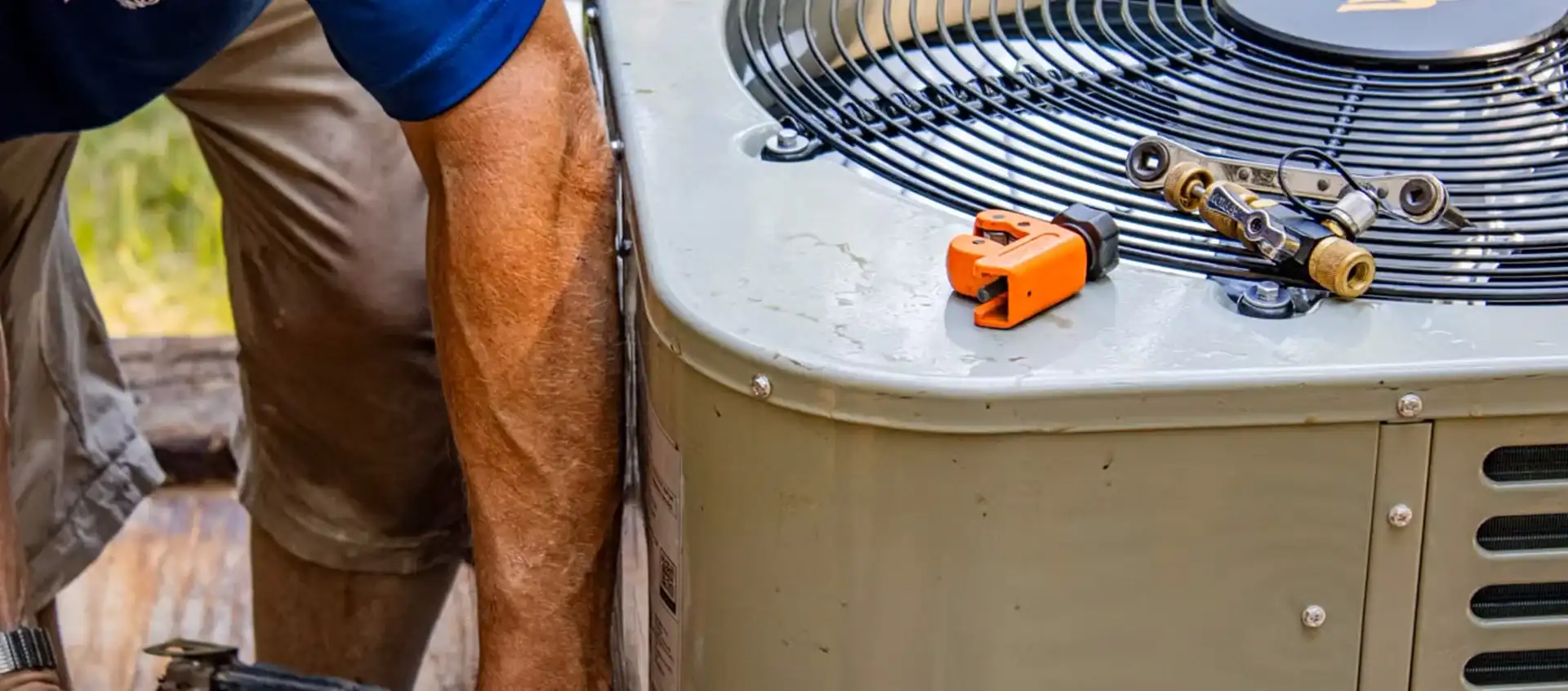 HVAC technician servicing an outdoor air conditioning unit.