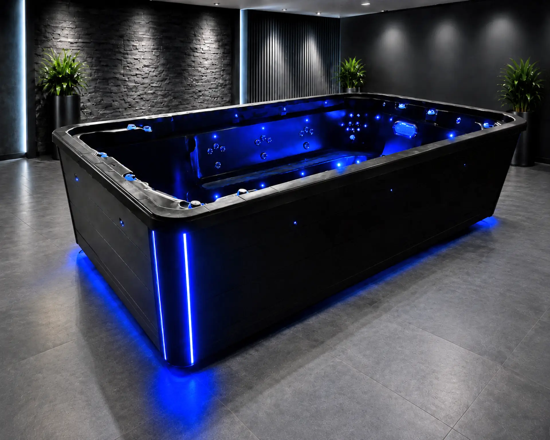 PDC Spas Midnight Series swim spa glowing blue in a dark showroom