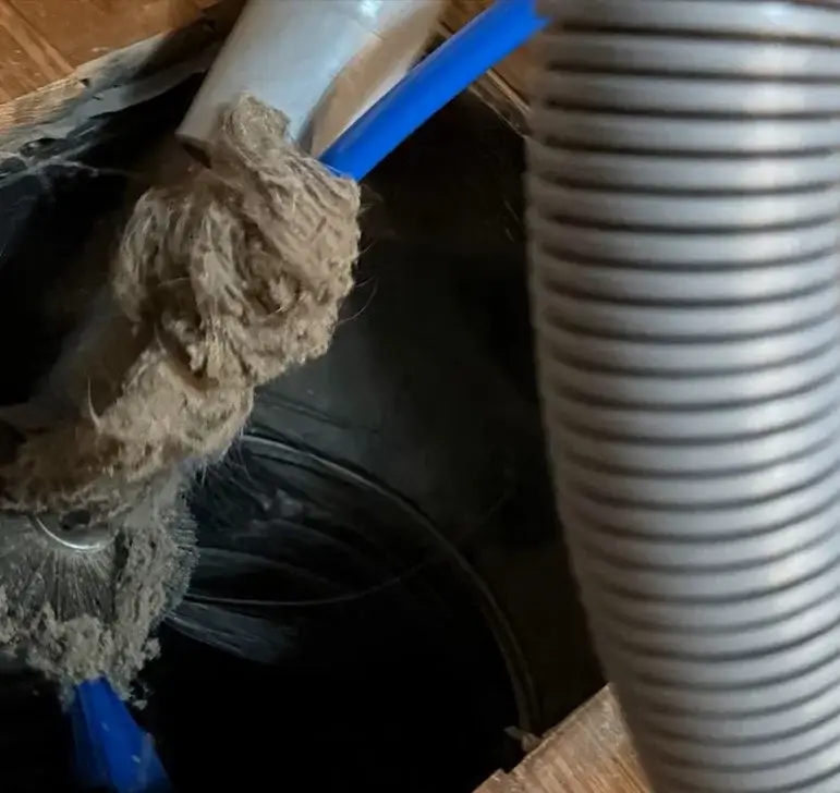Duct cleaning brush removing heavy dust buildup from HVAC ductwork.