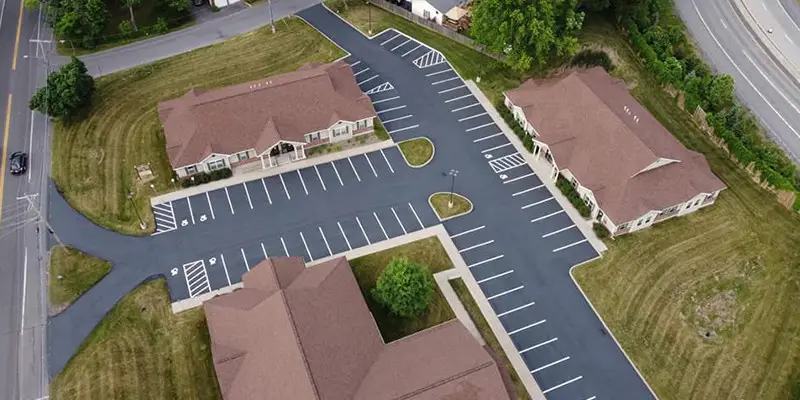 Aerial view of three buildings with a newly-paved parking lot.